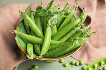 Bowl with tasty fresh peas on table