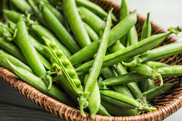 Obraz premium Basket with tasty fresh peas, closeup