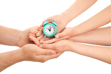 Fototapeta na wymiar Hands of family with alarm clock on white background