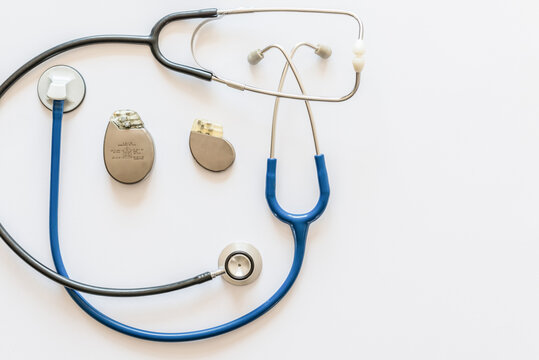 Two Blue And Black Stethoscopes On A White Background With Pacemaker Battery