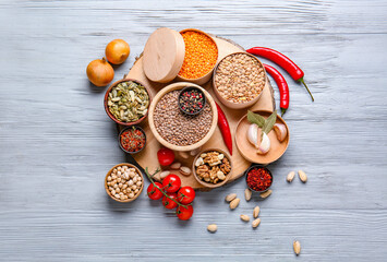 Different raw legumes with spices on table