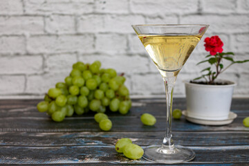 A glass of white wine on the table. The background is blurred