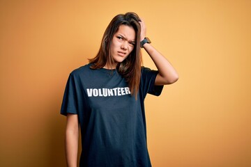 Young beautiful brunette girl doing volunteering wearing t-shirt with volunteer message word...