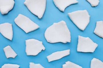 Coconut cut pieces on blue background.
