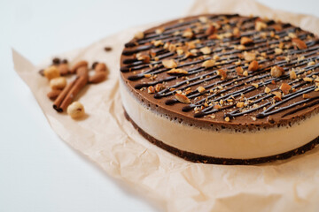 Homemade chocolate cake with nuts on parchment paper. Food delivery. Homemade baking. Top view. Delicious tart with chocolate and nuts on the wooden table.