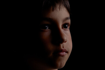 portrait of a boy on a dark background close up face