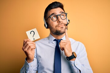 Business operator man with customer service headset from call center showing question mark serious...