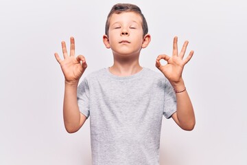 Cute blond kid wearing casual clothes relax and smiling with eyes closed doing meditation gesture with fingers. yoga concept.