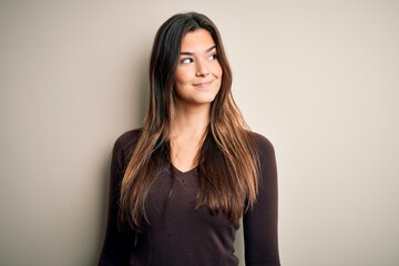 Obraz premium Young beautiful girl wearing casual sweater standing over isolated white background smiling looking to the side and staring away thinking.