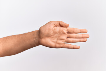 Hand of caucasian young man showing fingers over isolated white background stretching and reaching with open hand for handshake, showing palm