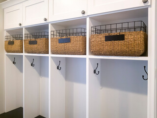 Fitted white wooden wall storage cabinet with shelves hooks and doors