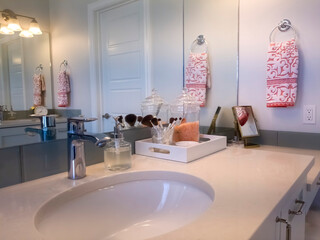 Bathroom with mirror makeup brushes and soap beside the sink and faucet