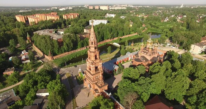 4K aerial summer morning video of red brick Gefsimanskiy skit grand cathedral church with golden cupolas in small vintage town Sergiev Posad in Moscow Oblast in central Russia