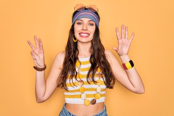 Young beautiful hippie woman with blue eyes wearing accesories and sunnglasses showing and pointing up with fingers number eight while smiling confident and happy.
