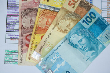 Brazilian money with calculator and numerical chart background