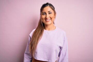 Obraz premium Young beautiful sport woman wearing sweatshirt over pink isolated background with a happy and cool smile on face. Lucky person.