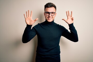 Young handsome caucasian man wearing glasses and casual sweater over isolated background showing...