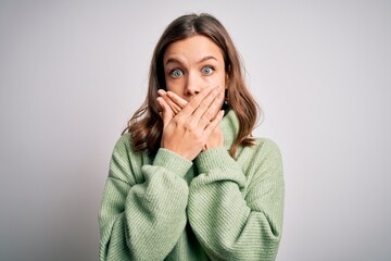 Young beautiful blonde girl wearing winter sweater standing over isolated background shocked covering mouth with hands for mistake. Secret concept.