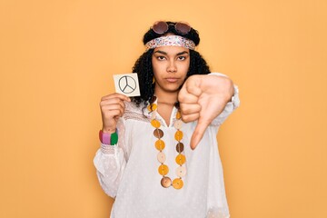African american curly hippie woman wearing sunglasses holding reminder with peace symbol with...