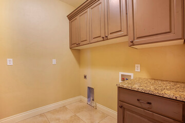 Interior of home kitchen with wood cabinets and gas line for cooking appliances