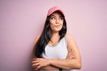 Obraz na płótnie Canvas Young brunette woman wearing casual sport cap over pink background smiling looking to the side and staring away thinking.