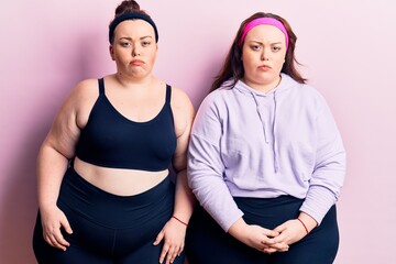 Obraz premium Young plus size twins wearing sportswear skeptic and nervous, frowning upset because of problem. negative person.