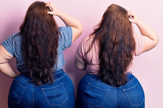 Young plus size twins wearing casual clothes backwards thinking about doubt with hand on head