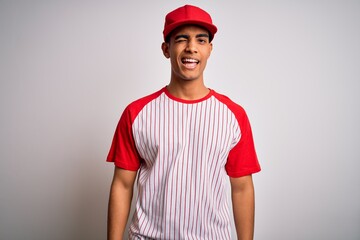 Young handsome african american sportsman wearing striped baseball t-shirt and cap winking looking at the camera with sexy expression, cheerful and happy face.