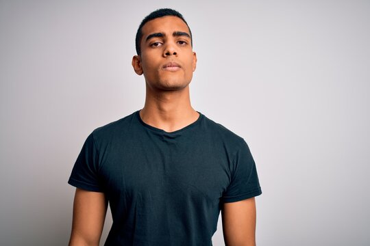 Young handsome african american man wearing casual t-shirt standing over white background depressed and worry for distress, crying angry and afraid. Sad expression.