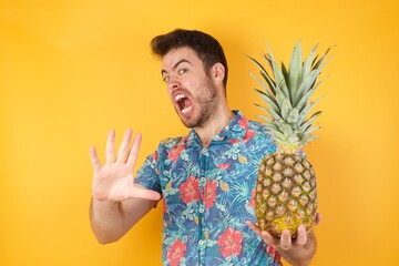Dissatisfied male model frowns face, has disgusting expression, shows tongue, expresses non...
