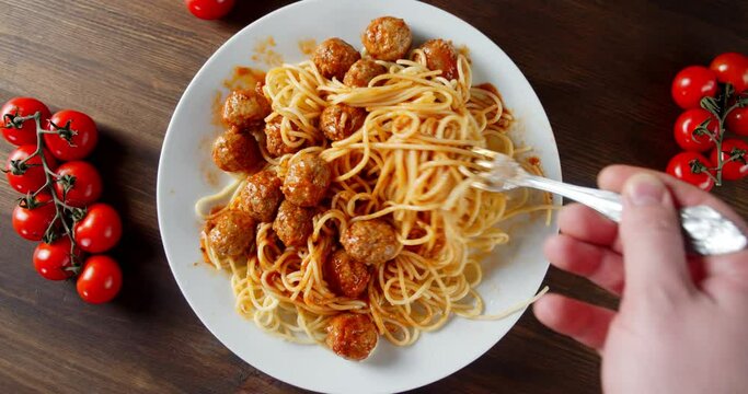 Ready meatballs mixed with fork with spaghetti.