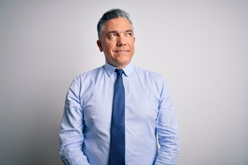 Middle age handsome grey-haired business man wearing elegant shirt and tie smiling looking to the side and staring away thinking.