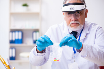 Old male expert criminologist working in the lab for evidence
