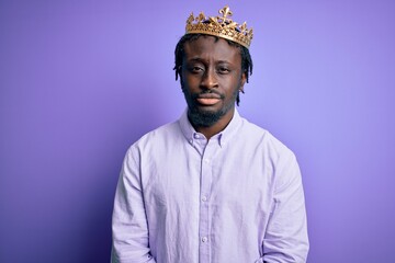 Young african american man wearing golden crown of king over isolated purple background depressed and worry for distress, crying angry and afraid. Sad expression.