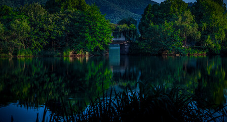 There is a bridge in the middle of the calm lake