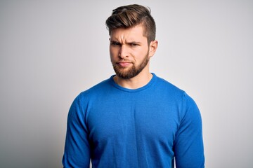 Fototapeta premium Young handsome blond man with beard and blue eyes wearing casual sweater skeptic and nervous, frowning upset because of problem. Negative person.