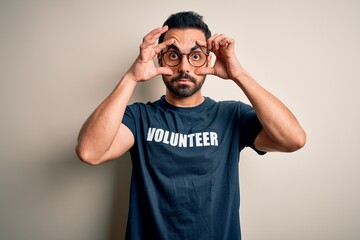 Handsome man with beard wearing t-shirt with volunteer message over white background Trying to open...