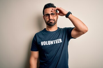 Handsome man with beard wearing t-shirt with volunteer message over white background worried and...