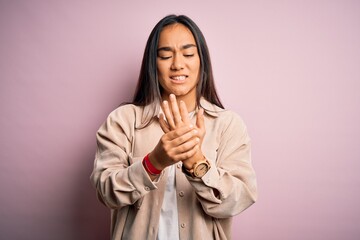 Young beautiful asian woman wearing casual shirt standing over pink background Suffering pain on...