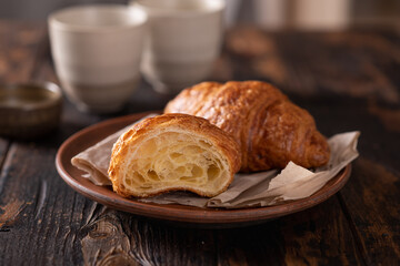 cut fresh croissants on a dark wooden background