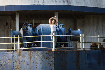 Young woman of mixed race in the abandoned giant ship in Thailand, posing for a photoshoot.