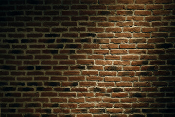 The texture of a brick wall with a light spot.