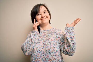 Young down syndrome woman having a conversation speaking on smartphone very happy and excited, winner expression celebrating victory screaming with big smile and raised hands