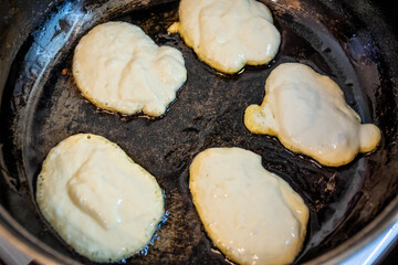 the dough is fried in a black pan with oil