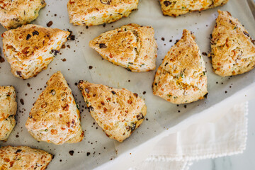 Bacon, cheddar and green onion scones on an aluminum baking sheet fresh out of the oven