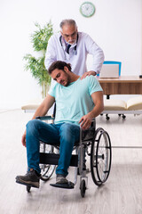 Fototapeta na wymiar Experienced doctor and young male patient in wheel-chair
