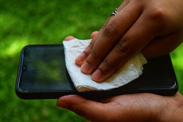 woman using smartphone and sanitizing it