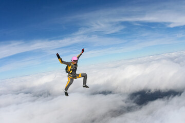 The girl parachutist performs figure freestyle in freefall.