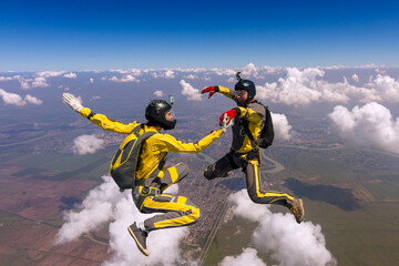 Fototapeta na wymiar Two sports parachutist build a figure in free fall. Extreme sport concept.