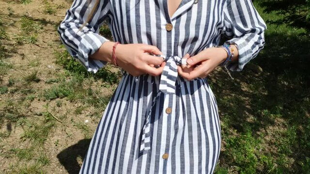 How to tie the strapon a summer dress on wais in a sunny day in a nature